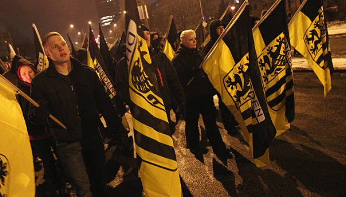 DRESDEN, GERMANY - FEBRUARY 13:  Neo-Nazis and their sympathizers march to commemorate the World War II firebombing of Dresden by Allied planes on February 13, 2012 in Dresden, Germany. Protesters attempted unsuccessfully to surround the expected 1,500 neo-Nazis with a human chain in order to prevent them from marching through the city in the annual event. Right-wing extremism is currently making national headlines in Germany due to the revelation that a pair of neo-Nazis claiming to be part of a group called the National Socialist Underground (NSU) murdered at least 10 immigrant small-business owners as well as a policewoman over a decade-long period, and that police investigations at the time were either botched or willfully aborted.  (Photo by Sean Gallup/Getty Images)