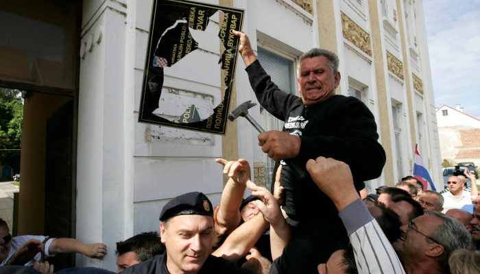 - 2013. U FOTOGRAFIJAMA CROPIX-A -

Vukovar, 020913.
 Branitelji i clanovi Stozera za obranu hrvatskog Vukovara, unatoc zastiti interventne policije skinuli su jutros postavljene ploce s dvojezicnim natpisom sa zgrada drzavnih institucija.
Na fotografiji: policijska stanica u Vukovaru na kojoj je jutros postavljena dvojezicna ploca, plocu je skinuo vukovarski branitelj Marijan Zivkovic.
Foto: Vlado Kos / Cropix